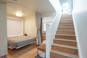 A bedroom with a bed, a wooden staircase, and a window. - French Street Chalet - Downtown Breckenridge, 30+ Day Rental (Breckenridge)