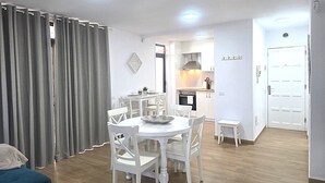 A modern apartment with a dining area, kitchen, and a small balcony. - Librada Home Playa Las Americas (Playa de las Américas)