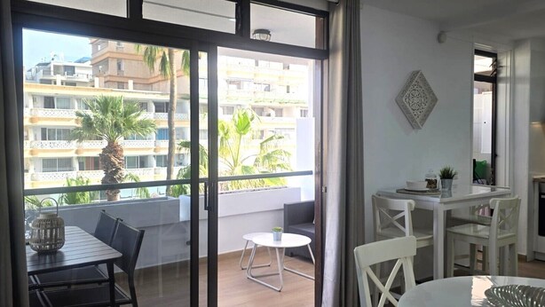A modern apartment with a balcony, a dining area, and a kitchen. - Librada Home Playa Las Americas (Playa de las Américas)