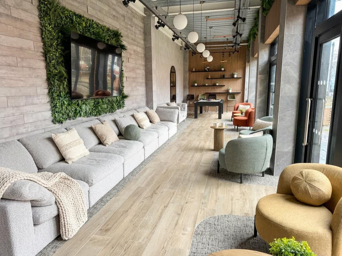 Un área de descanso moderna con un sofá, sillones y una mesa de centro.
