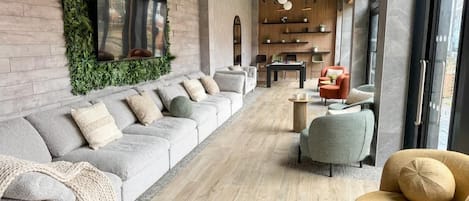 A modern lounge area with a sofa, armchairs, and a coffee table.