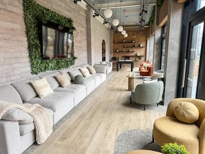A modern lounge area with a sofa, armchairs, and a coffee table.