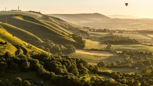A panoramic view of rolling hills with a hot air balloon in the sky. - Buttercup - Super King Ensuite Room in Sidlesham (Chichester)