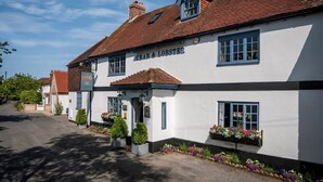 A traditional pub with a white facade, multiple windows, and a sign reading 'CRAB & LOBSTER'. - Wren Barn - Cosy 2-bed Converted Barn in Sidlesham (Chichester)