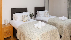 A bedroom with two beds, wooden beams, skylights, a bedside table, and a mirror. - Clover - Super King Ensuite Room in Sidlesham (Chichester)