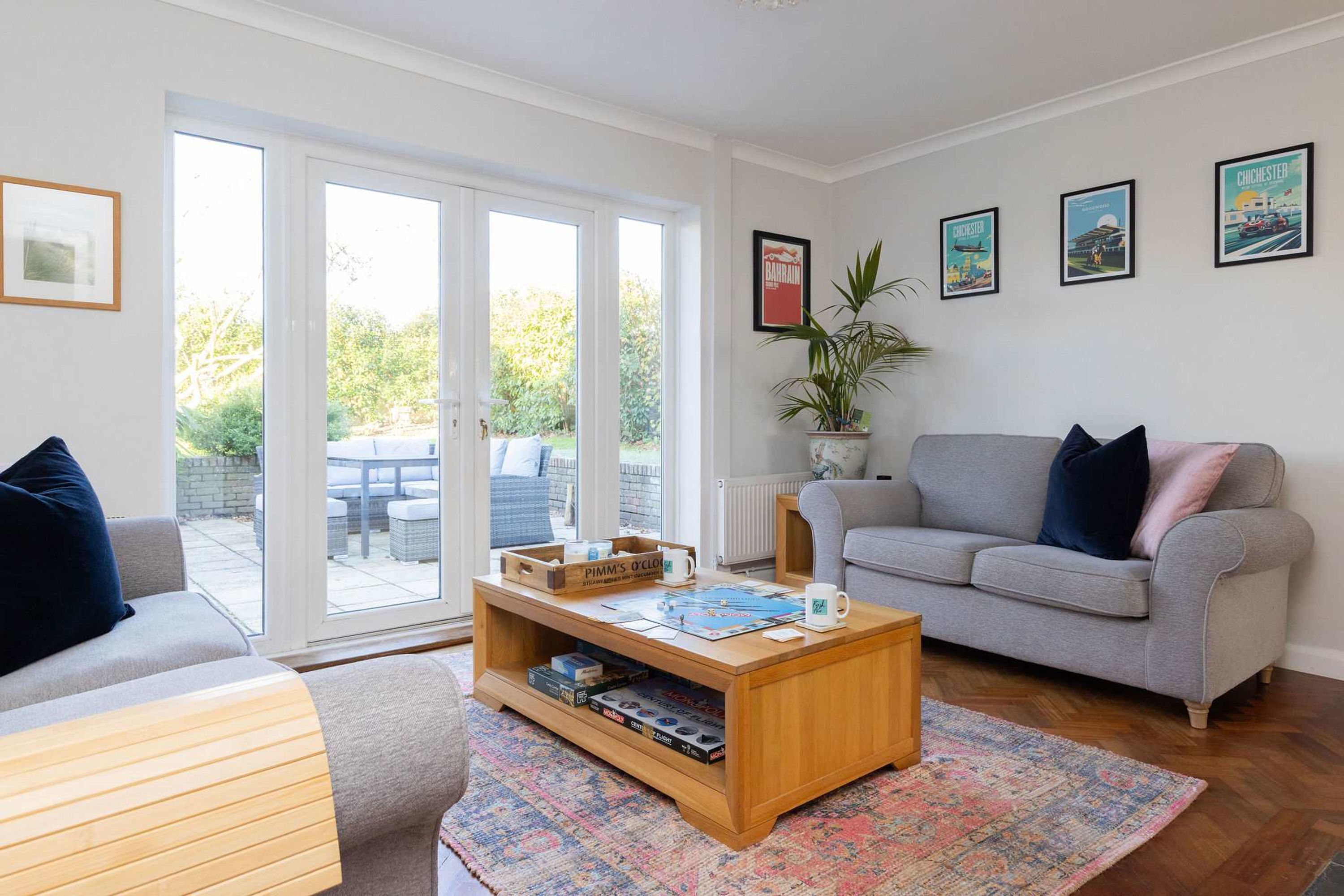 Sala de estar con sofá, mesa de centro y vistas al exterior a través de un ventanal.