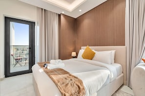 Ein modernes Hotelzimmer mit einem großen Bett, einem Balkon mit Stuhl und Blick auf die Stadt.