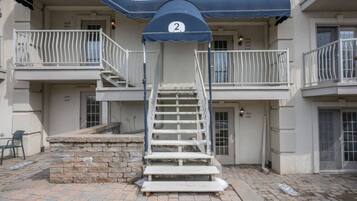 A building with a blue awning, a staircase, and a stone platform.