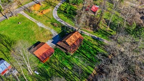 An aerial view of a rural property with a winding road, a barn, and a small house. - Caney Creek Retreat 1 Bedroom Cabin (Cosby)