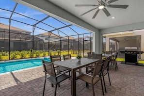 A covered patio with a pool, outdoor seating, and a grill area. - 10 Bedroomss/ Windsor Island Home (Davenport)