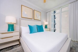 Ein Hotelzimmer mit einem großen Bett, zwei Nachttischen, einer Kopfteil und zwei gerahmten Kunstwerken an der Wand.