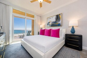 A hotel room with a large bed, a desk, a chair, and a view of the ocean. - Phoenix Orange Beach Ii 505 4 Bedroom Condo (Orange Beach)