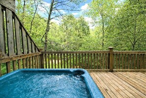 A hot tub on a wooden deck surrounded by trees. - Adorable Shut'er Inn 1 Bedroom Cabin (Pigeon Forge)