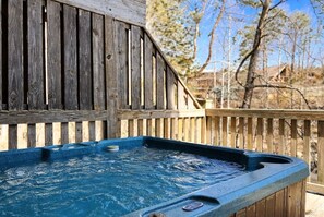 A wooden deck with a hot tub. - Adorable Shut'er Inn 1 Bedroom Cabin (Pigeon Forge)