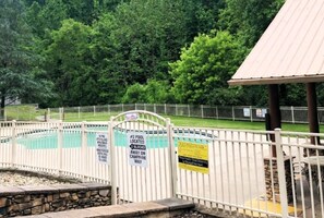 A fenced pool area with signs indicating pool location and safety instructions. - Adorable Shut'er Inn 1 Bedroom Cabin (Pigeon Forge)