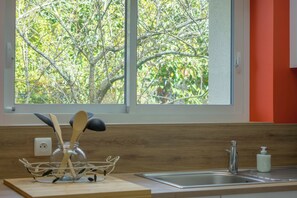 Une cuisine avec une fenêtre, un évier et un plan de travail en bois.