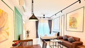 Un salon moderne comprenant un coin repas, un canapé, une table basse et des œuvres d’art accrochées aux murs.