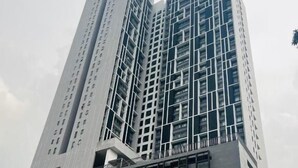 Un immeuble de grande hauteur doté d’une architecture moderne, caractérisé par une façade en forme de grille et de nombreux balcons.