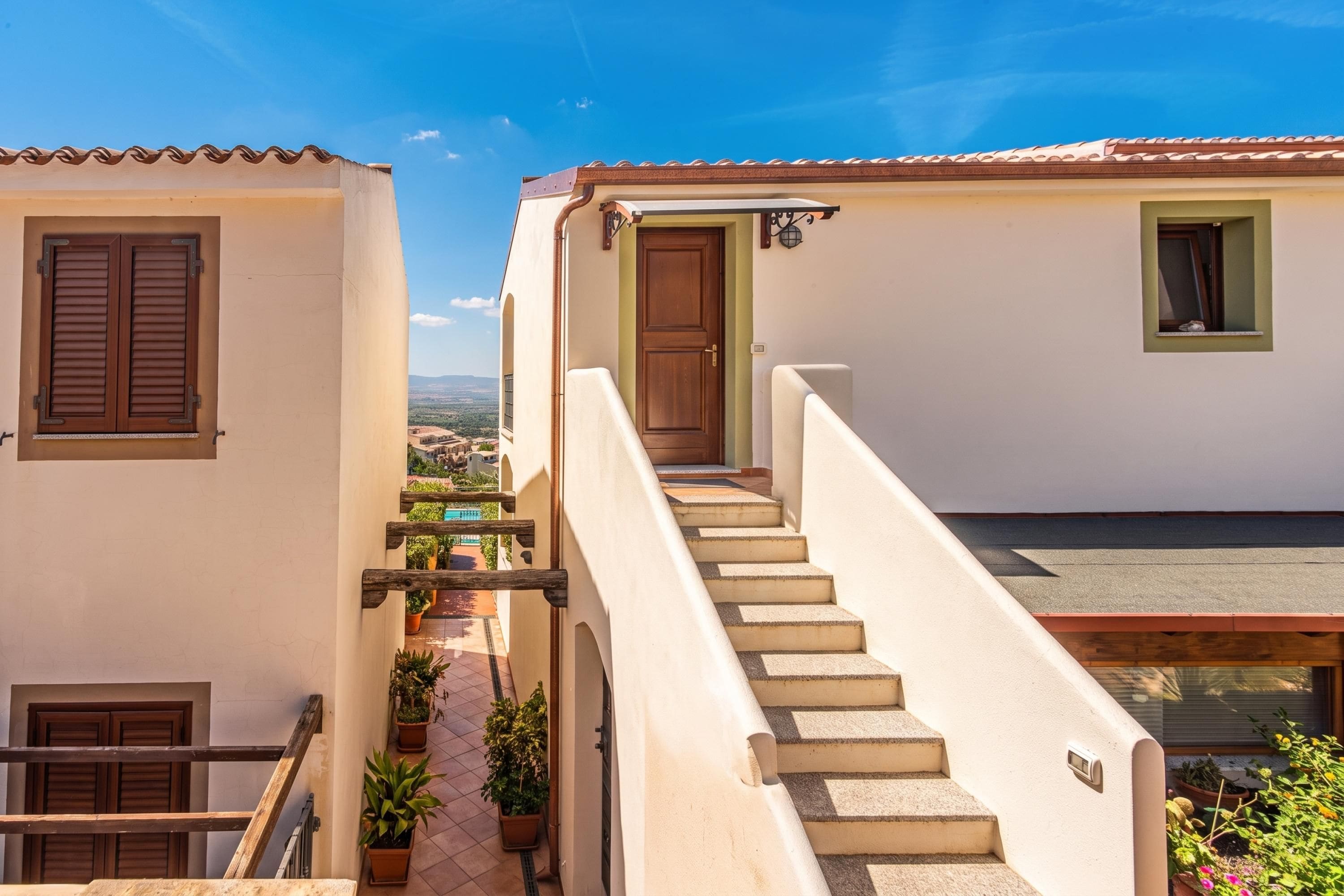 Un escalier menant à une porte qui donne sur un paysage en arrière-plan.