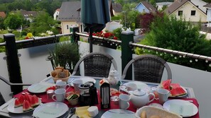 Une table mise pour le petit-déjeuner, avec des assiettes, des tasses et une variété d'aliments.