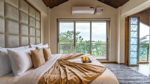 Un dormitorio con una cama grande, vistas por la ventana y un equipo de aire acondicionado.