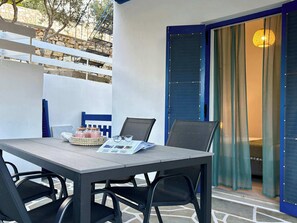 A patio area with a table, chairs, and a blue door. - Origins III | Modern Seaside Studio in Piso Livadi (Piso Livadi Paros)