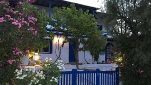 Ein traditionelles Gebäude mit einer blauen Tür, einer weißen Wand und einem blauen Zaun.