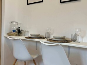 A dining table set with plates, glasses, and a candle holder. - Origins II | Calm Studio near Beach & Taverns (Piso Livadi Paros)