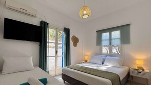 Ein Schlafzimmer mit einem Bett, einem Nachttisch, einer Lampe, einem Fenster und einer Klimaanlage.