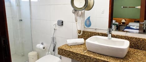 Un baño con ducha, inodoro y lavamanos con encimera de granito.