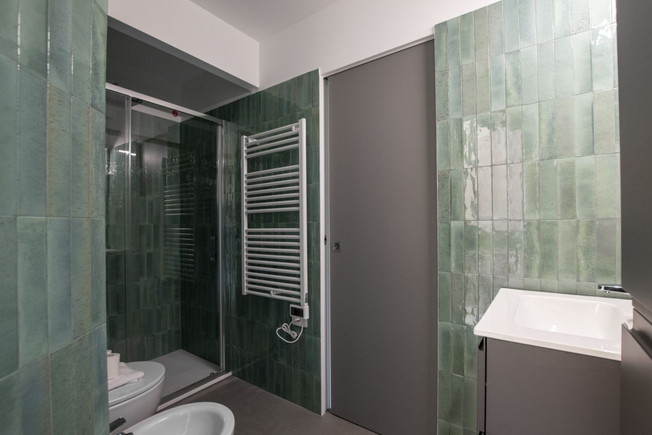 Un baño con cabina de ducha de vidrio, una bañera blanca y un lavamanos.