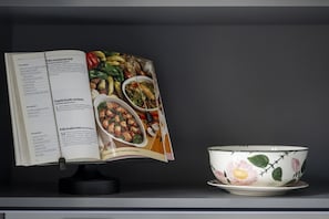An open cookbook with recipes on the left page and a bowl with a floral design on the right. - Bright Top Floor Flat with Balconies & AC - Loreto & Porta Venezia (Milano)