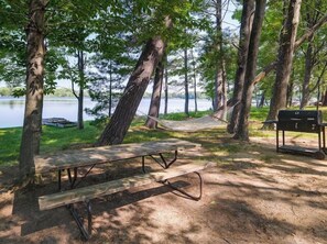 Outdoor dining - Lakefront cottage on Crawford Lake with 2 kayaks, private dock, and outdoor seating. Large driveway for ATV trailers with direct trail access. Near golf courses, other lakes, and just 35 minutes to Traverse City. The perfect summer escape! 🌊☀️ (Kalkaska)
