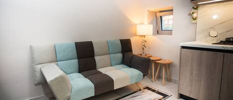 Ett modernt kök med en soffa, en lampa och ett litet bord.