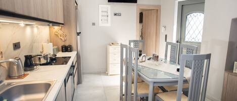 A modern kitchen with a dining area, built-in appliances, and a flat-screen TV.