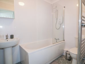 A bathroom with a white sink, a bathtub, a toilet, and a shower. - Seahorses (Padstow)