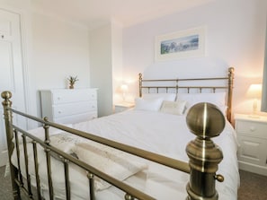 A bedroom with a bed, bedside tables, a dresser, and a framed picture on the wall. - Seahorses (Padstow)