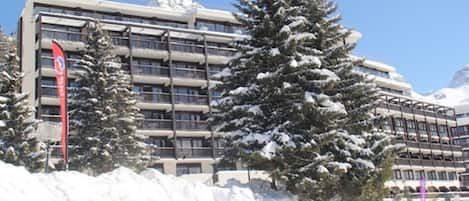 A multi-story hotel with a modern architectural design, featuring balconies and large windows.