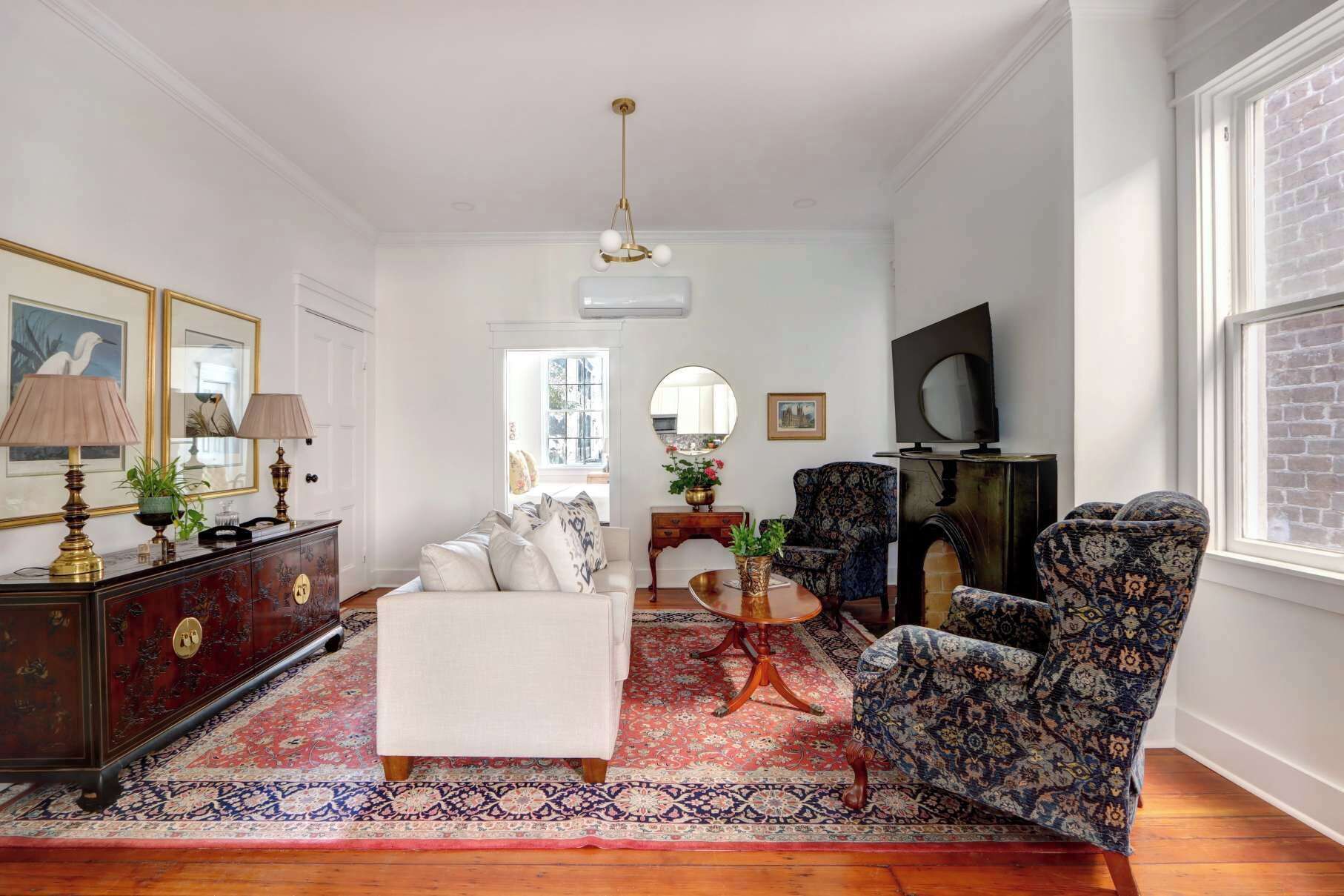 Un salon comprenant un canapé, des fauteuils, une table basse, un téléviseur et une cheminée.