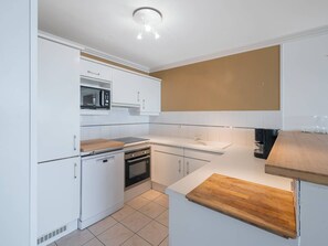 A modern kitchen with white cabinetry, a microwave, an oven, and a wooden countertop. - Apartment sea view, pets allowed - ? guests (Le Touquet-Paris-Plage)