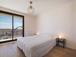 A bedroom with a large window, a bed, a bedside table, and a unique hexagonal ceiling light. - Apartment sea view, pets allowed - ? guests (Le Touquet-Paris-Plage)