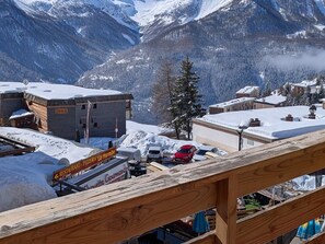 Une ville de montagne enneigée, avec un restaurant appelé « Ristorante La Marmita » et une vue sur des montagnes aux sommets enneigés.