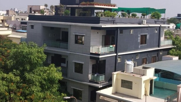 A multi-story building with balconies, a satellite dish, and a water tank on the roof. - Stay10 Luxury Service Apartment (Indore)