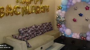 A room with a sofa, a wall decoration with balloons, and a table. - Stay10 Luxury Service Apartment (Indore)