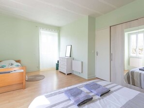 A bedroom with a bed, a dresser, a radiator, and a wardrobe. - House in bastide, pets allowed - 5 guests (MONTFAUCON)