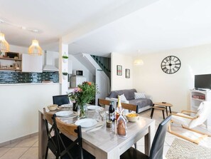 A modern living space with a dining area, kitchen, and seating area.