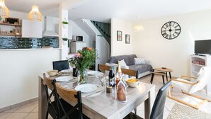 Een modern appartement met een eetgedeelte, keuken, woonkamer en een trap.
