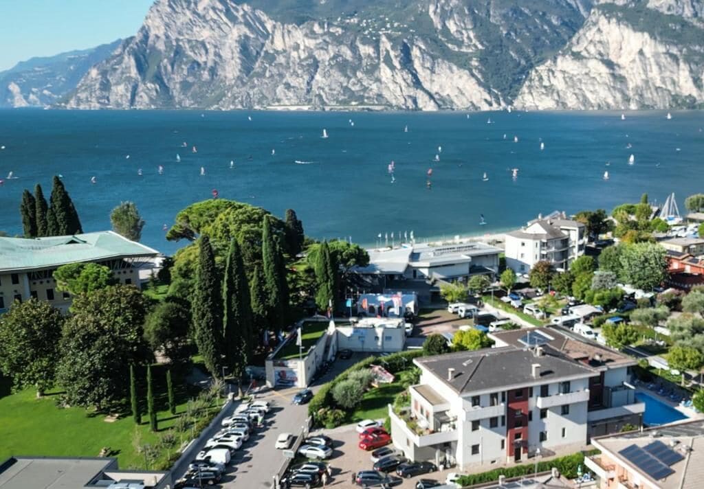 Un pueblo costero con un puerto deportivo, edificios y montañas al fondo.