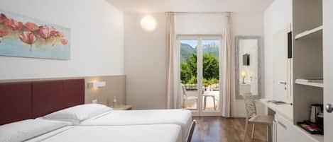 A hotel room with two beds, a painting, a desk, a chair, and a view of the outdoors.