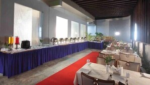 A conference room with a long table, red carpet, and potted plants. - Casa In Luxury Suites (Thiruvananthapuram)